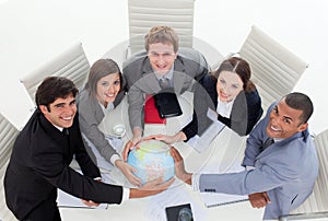 A diverse business team holding a terrestrial glob