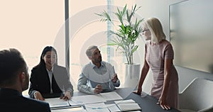 Diverse business team meeting with mature speaker in office boardroom