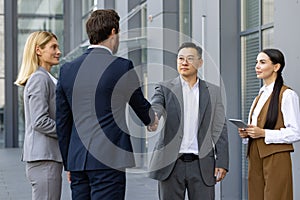 Diverse business team shaking hands during outdoor introduction meeting