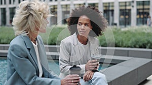 Diverse business women having coffee break outdoors