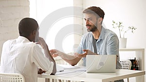 Diverse businessmen negotiating, talking discussing business deal at office desk