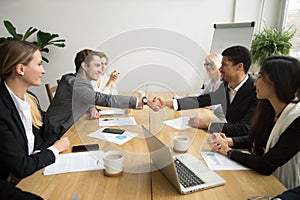 Diverse businessmen shaking hands after signing contracts at gro