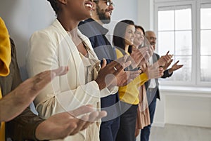 Diverse businesspeople clap hands at business meeting