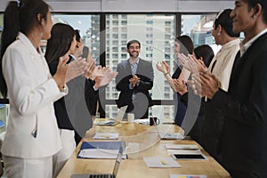 Diverse businesspeople clapping hands together to celebrate success