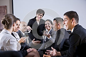 Diverse businesspeople conversing, woman at front
