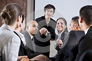 Diverse businesspeople conversing, woman at front