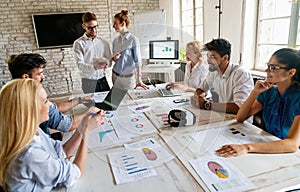 Diverse businesspeople discuss financial report in charts diagrams and graphs in meeting