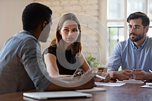 Diverse businesspeople gathered in office solving issues working on project