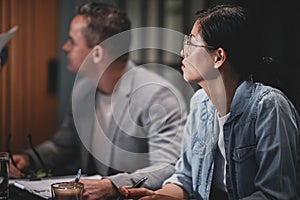 Diverse businesspeople listening to a speaker during a meeting