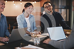 Diverse businesspeople meeting together around a table in an off