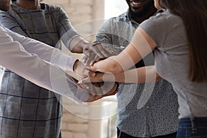 Diverse businesspeople stacking hands together engaged in team building