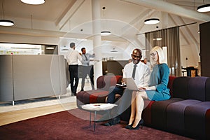 Diverse businesspeople working together on a sofa in an office