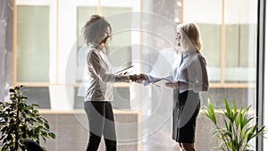 Diverse businesswomen handshake getting acquainted in office