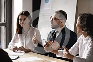 Diverse businesswomen laughing at colleague joke at corporate meeting