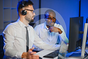 Diverse call center operators team use computers consulting clients in office