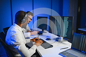 Diverse call center operators team use computers consulting clients in office