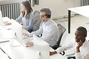 Diverse call center operators team working on computers in office