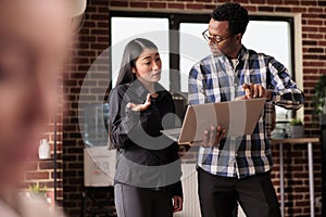Diverse coders looking at security firewall on laptop