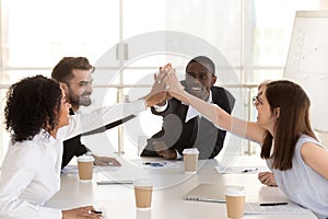 Diverse colleague giving high five, celebrating corporate success