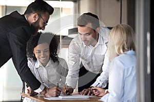 Diverse colleagues brainstorm cooperating at meeting in office