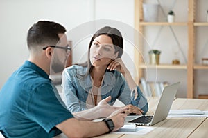 Diverse colleagues brainstorm using laptop at meeting