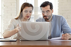 Diverse colleagues discuss business project work on laptop