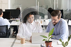 Diverse colleagues discussing computer work at workplace