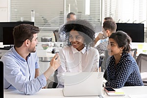 Diverse colleagues discussing online project at workplace