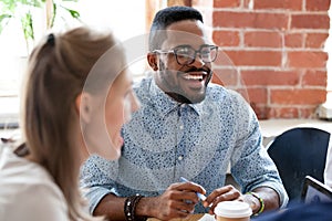 Diverse colleagues have fun laughing during casual office meetin