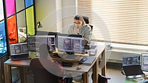Diverse Colleagues Writing Code on Desktop Computers With Professional Multiple Monitors Setup