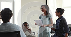 Diverse company employees talking at meeting in coworking office