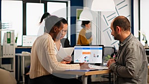 Diverse company staff group talking sitting at desk in modern office