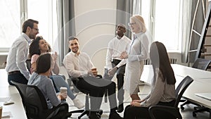 Diverse corporate team having coffee break at coworking room