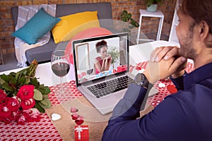 Diverse couple making valentine's date video call the woman on laptop screen with glass of wine