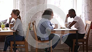 Diverse couples sitting at table in cafe participates speed dating