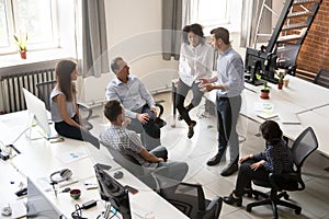 Diverse coworkers informal meeting with male CEO discussing plans