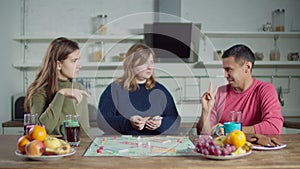 Diverse deaf friends playing board game in kitchen