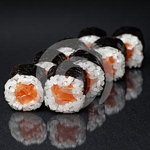 Diverse delicious sushi roll set on a black background with reflection, menu