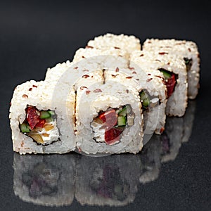 Diverse delicious sushi roll set on a black background with reflection, menu