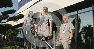 Diverse doctors in uniforms stand outdoors at the hospital entrance