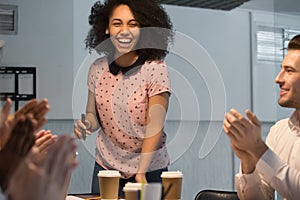 Diverse employees applaud thanking happy black female presenter photo