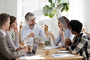 Diverse employees brainstorm at business office meeting