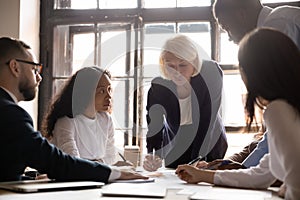 Diverse employees discuss financial business paperwork at briefing