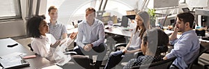 Diverse employees gathered brainstorming together in co working office room