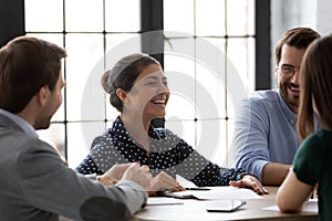 Diverse employees laughing enjoy friendly talk during briefing