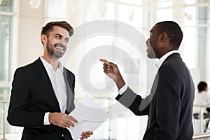 Diverse employees laughing at joke during break in office