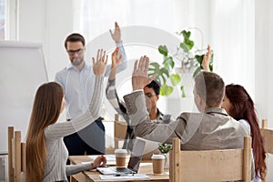 Diverse employees raise hands involved in teambuilding activity