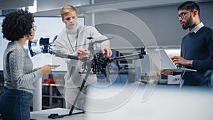 Diverse Engineers Brainstorming and Using Laptop Computer. Caucasian Male Sets Up Modern Drone