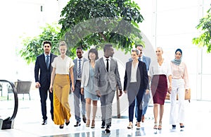 Diverse executives walking in the same direction in hall