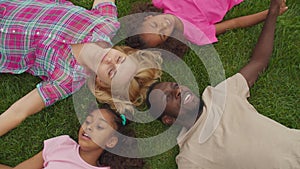 Diverse family lying head to head in circle on grass